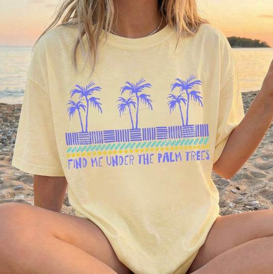 Person wearing a yellow t-shirt with palm tree design on a beach
