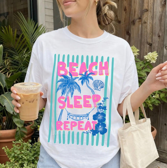 Person wearing a white t-shirt with 'Beach Sleep Repeat' design, holding a drink and a bag.