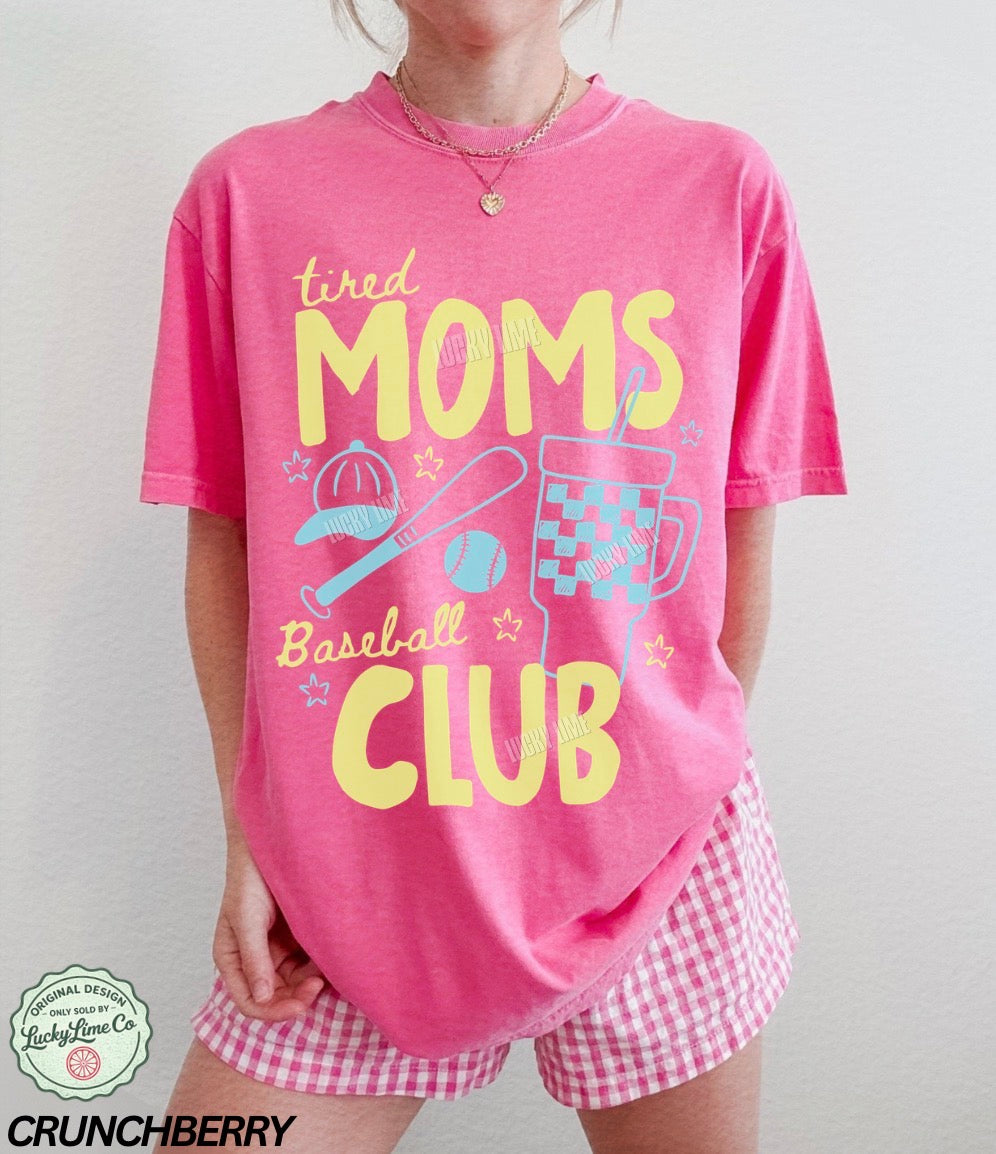Pink t-shirt with 'tired moms baseball club' text and graphics, worn by a person.