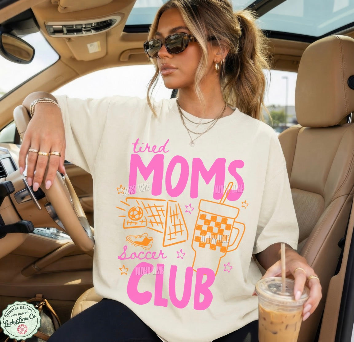 Woman sitting in a car wearing a t-shirt with 'tired moms soccer club' text.