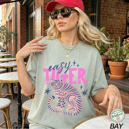 Woman wearing a t-shirt with a tiger design and text in an outdoor setting