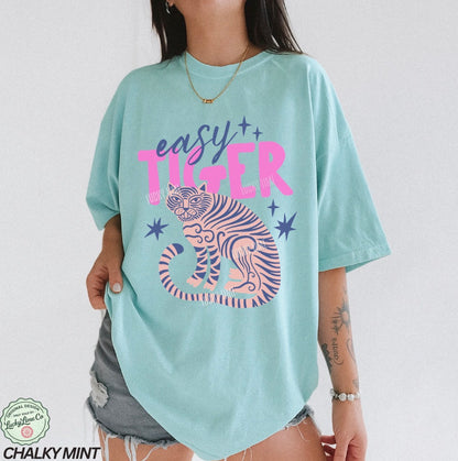 Person wearing a light blue t-shirt with 'easy tiger' design and text.