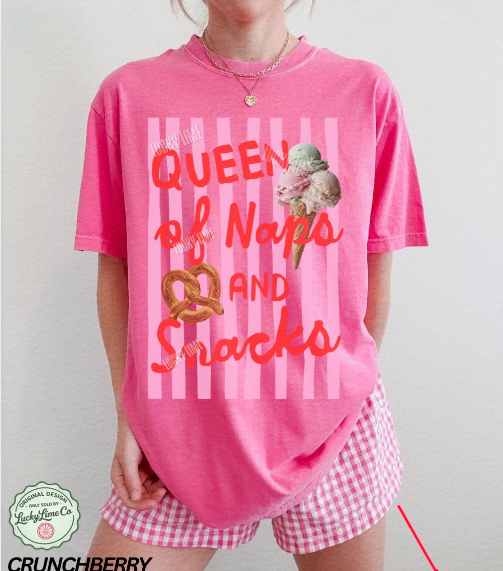 Person wearing a pink 'Queen of Naps and Snacks' t-shirt with ice cream graphic.