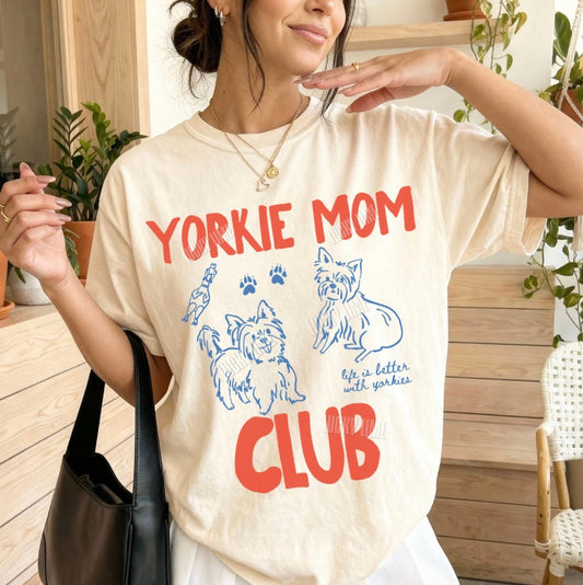 Woman wearing a 'Yorkie Mom Club' t-shirt outdoors