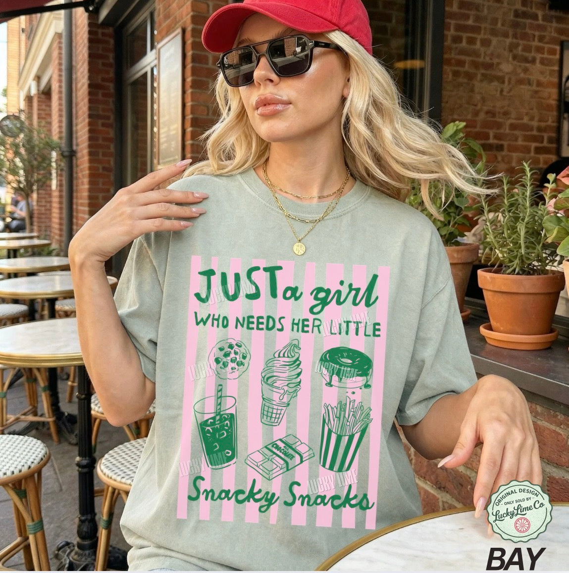 Woman wearing a t-shirt with a snack-themed design in an outdoor setting.