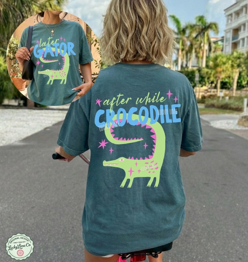 Person wearing a t-shirt with a crocodile graphic and text, standing outdoors.