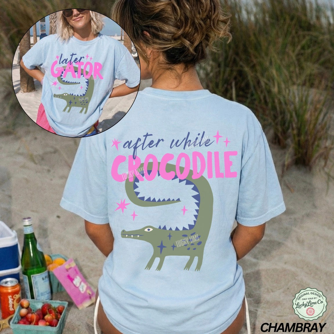 Person wearing a light blue t-shirt with a crocodile graphic and text on a beach.