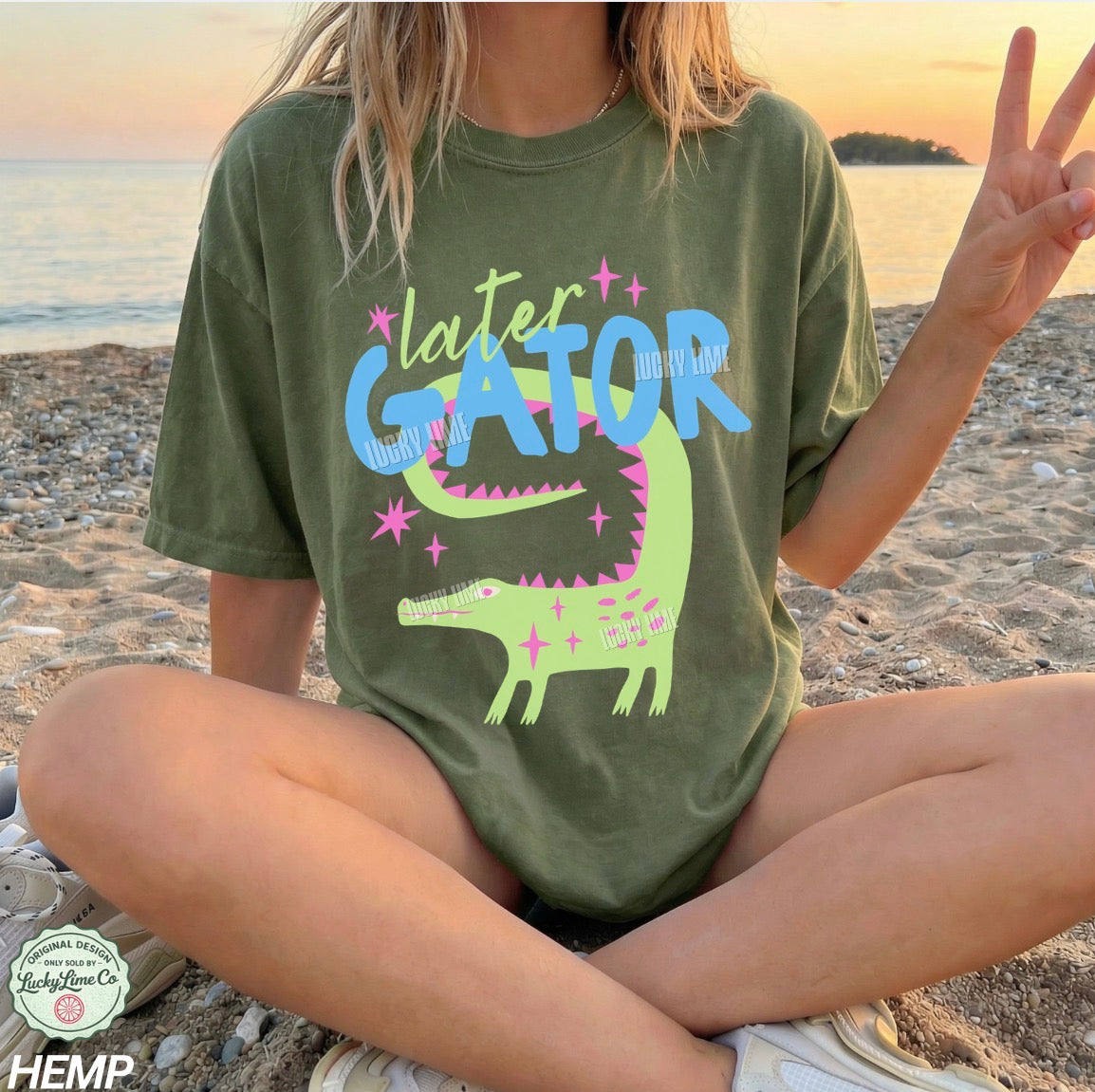Person wearing a green t-shirt with 'later GATOR' design on a beach.