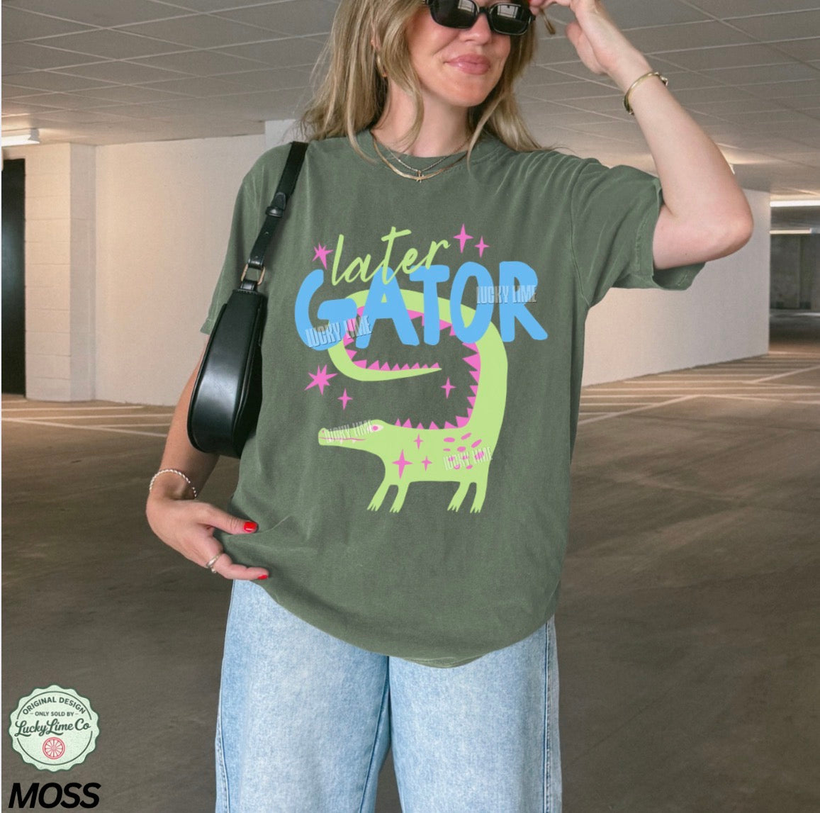 Person wearing a green t-shirt with 'later gator' graphic in an indoor setting