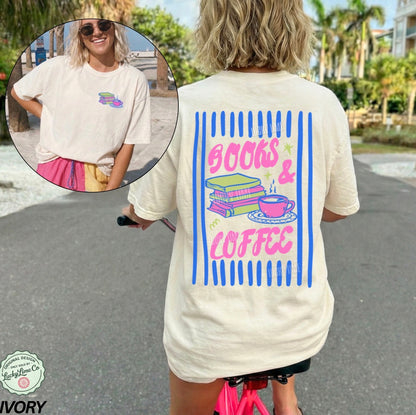 Person wearing a t-shirt with 'Books & Coffee' design outdoors.