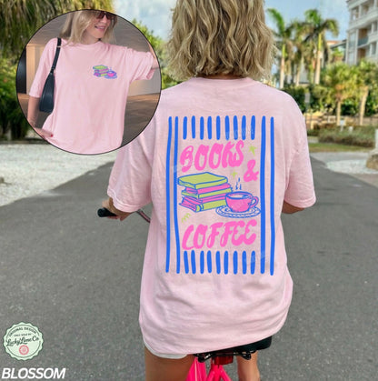 Person wearing a pink t-shirt with 'Books & Coffee' design outdoors.