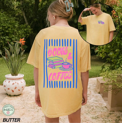 Person wearing a yellow t-shirt with 'Books & Coffee' design outdoors.