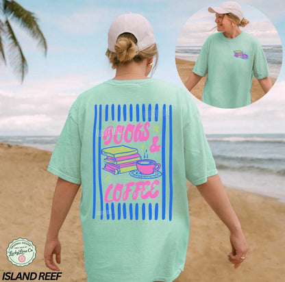 Person wearing a light green t-shirt with 'Books & Coffee' design on a beach.