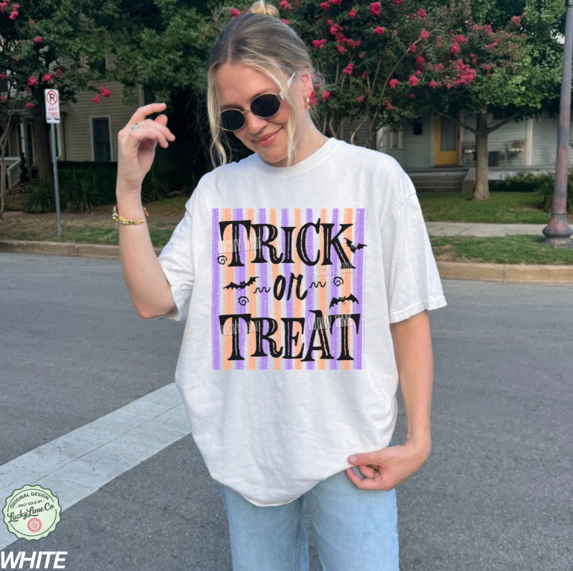 Person wearing a 'Trick or Treat' shirt on a street.