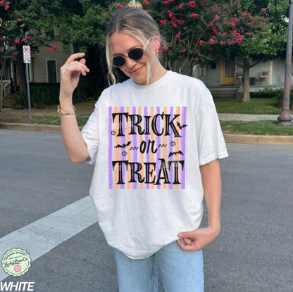 Person wearing a 'Trick or Treat' shirt on a street.