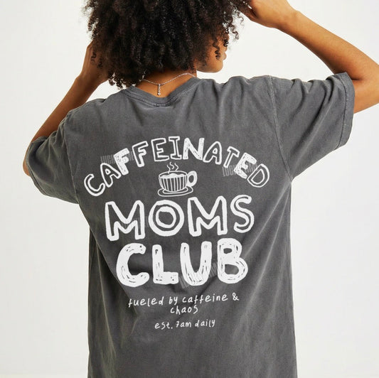 Person wearing a gray t-shirt with 'Caffeinated Moms Club' text on the back