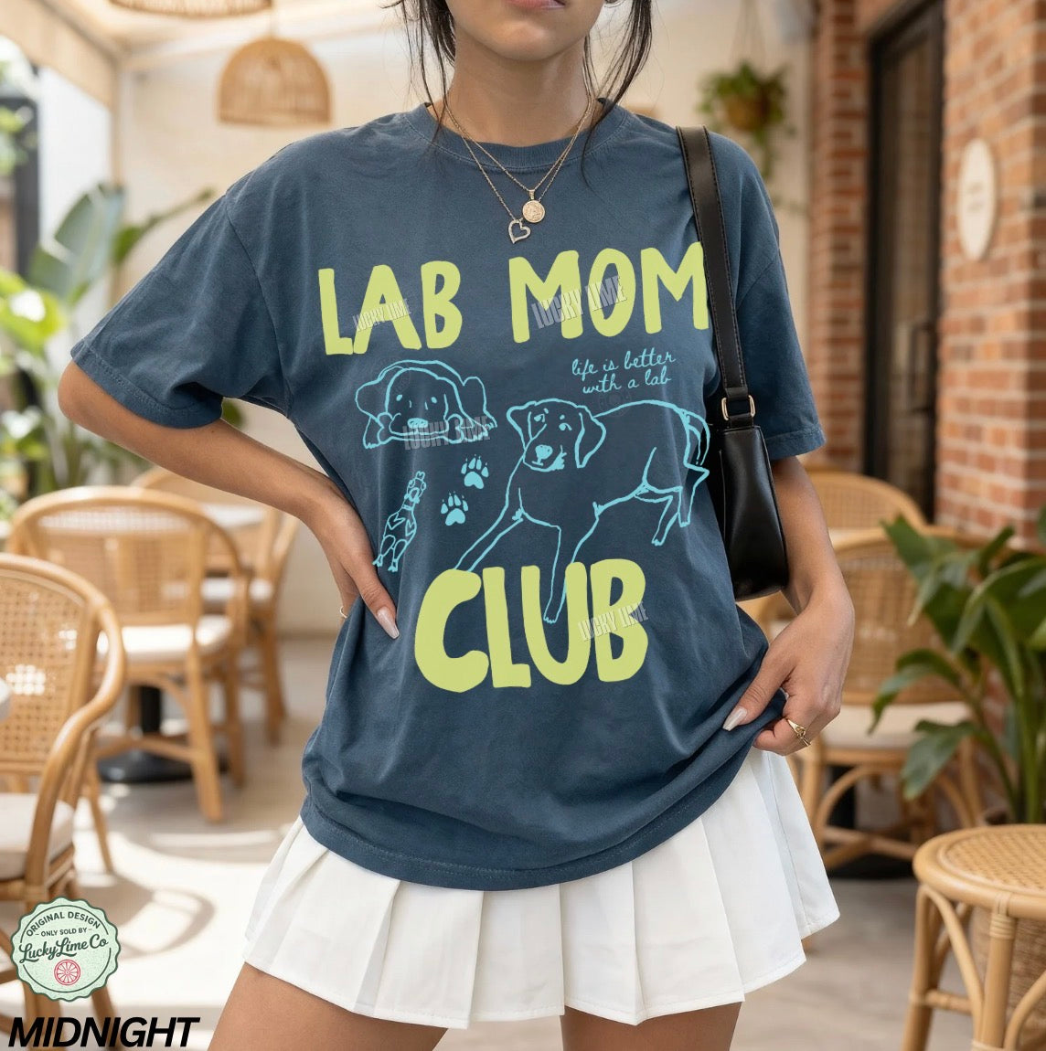 Person wearing a blue t-shirt with 'Lab Mom Club' design in a casual setting.