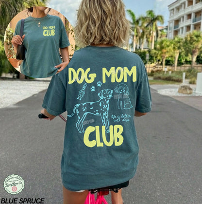 Person wearing a 'Dog Mom Club' t-shirt with a graphic of a dog and text on the back, standing outdoors.