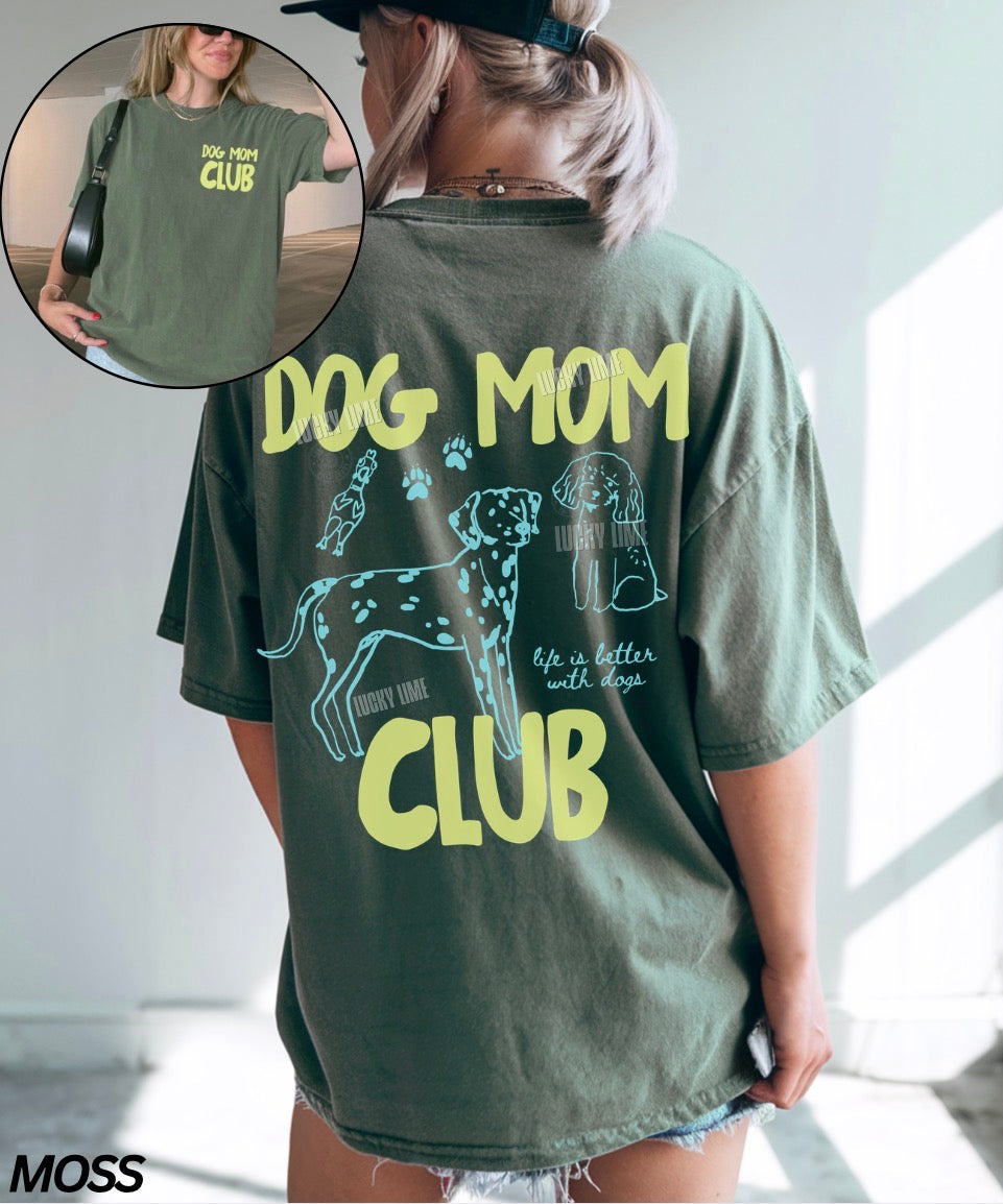 Person wearing a green 'Dog Mom Club' t-shirt with text and graphics.