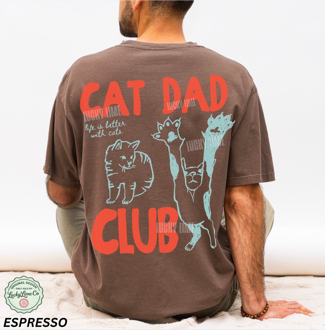 Person wearing a brown t-shirt with 'Cat Dad Club' design and text.