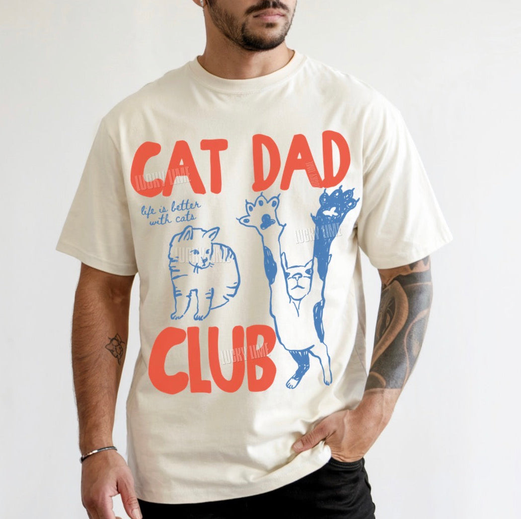 Man wearing a 'Cat Dad Club' t-shirt with cat illustrations on a white background