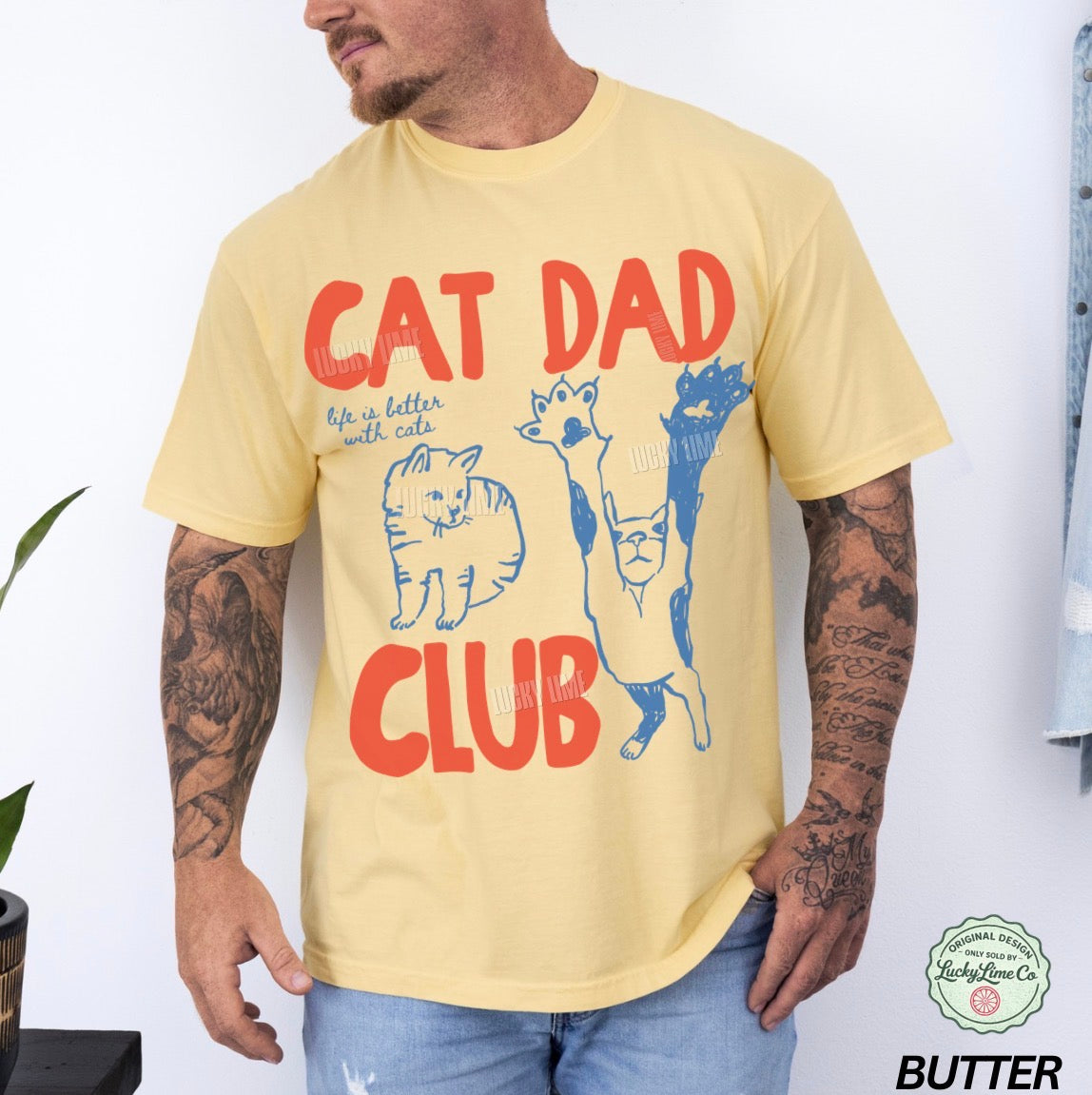 Man wearing a yellow t-shirt with 'Cat Dad Club' design and visible brand logo.