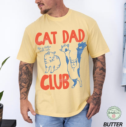 Man wearing a yellow t-shirt with 'Cat Dad Club' design and visible brand logo.