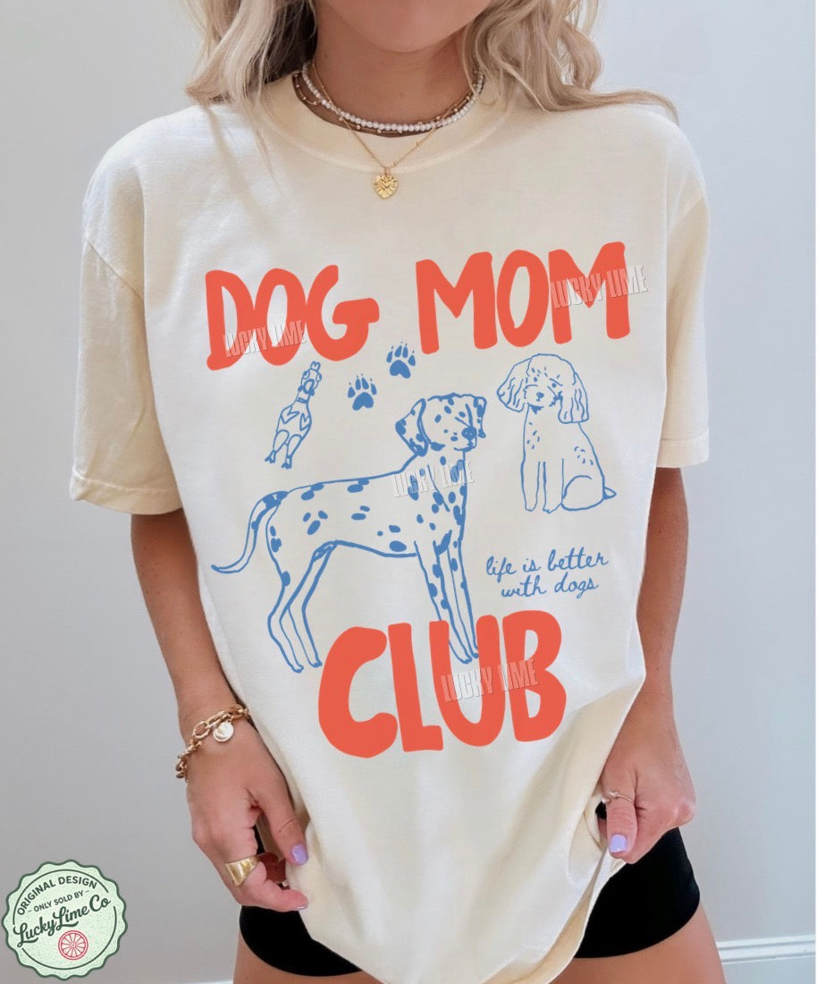 Person wearing a 'Dog Mom Club' t-shirt with dog illustrations and text.