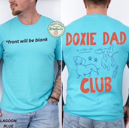 Light blue t-shirt with 'Doxie Dad Club' design on the back, featuring text and illustrations of dachshunds.