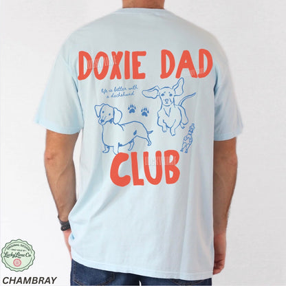 T-shirt with 'Doxie Dad Club' text and dachshund illustrations on a plain background