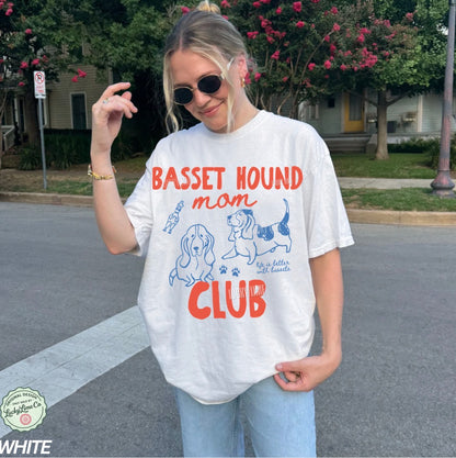 Person wearing a 'Basset Hound Mom Club' t-shirt on a street.