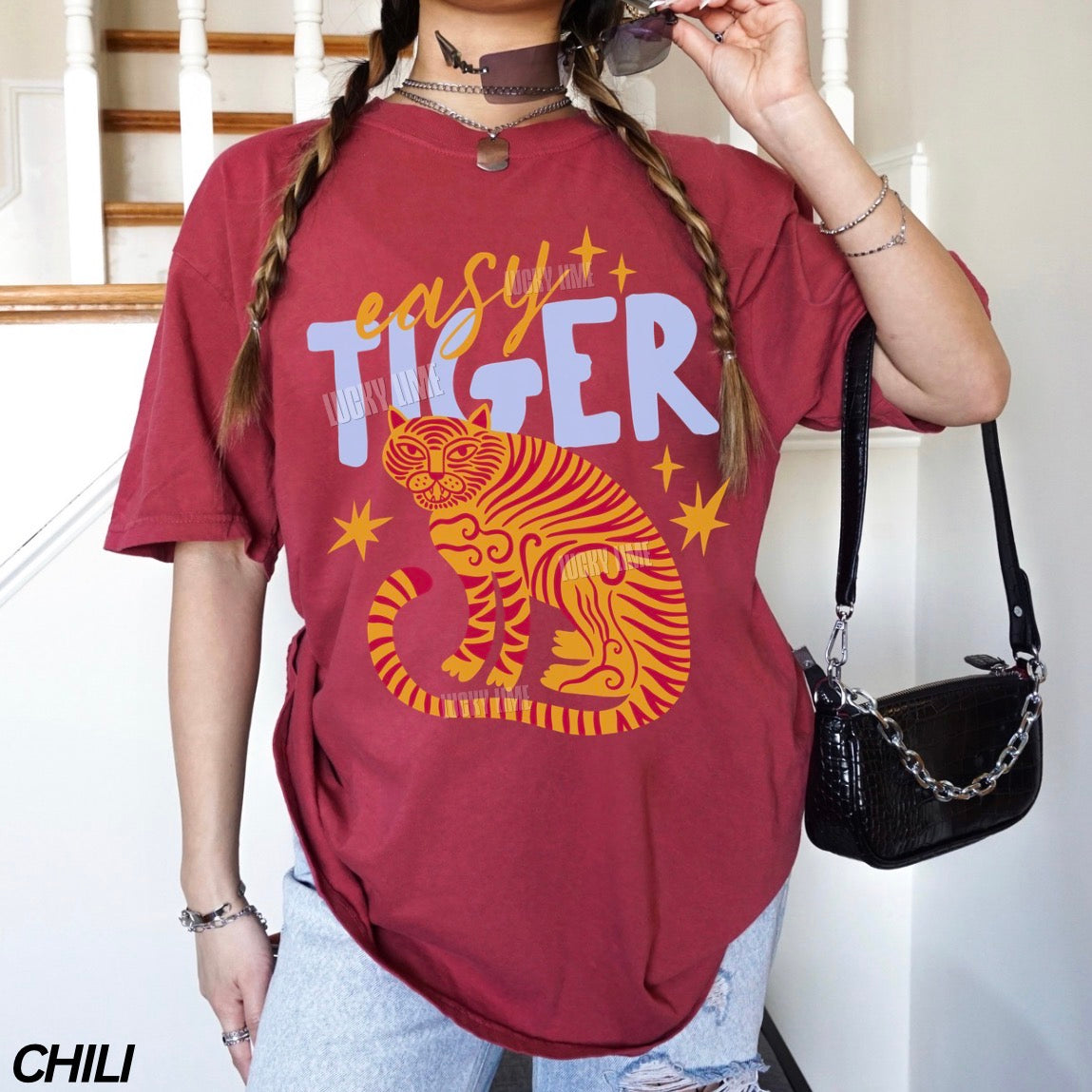 Person wearing a red 'easy tiger' t-shirt with a tiger graphic, standing indoors.