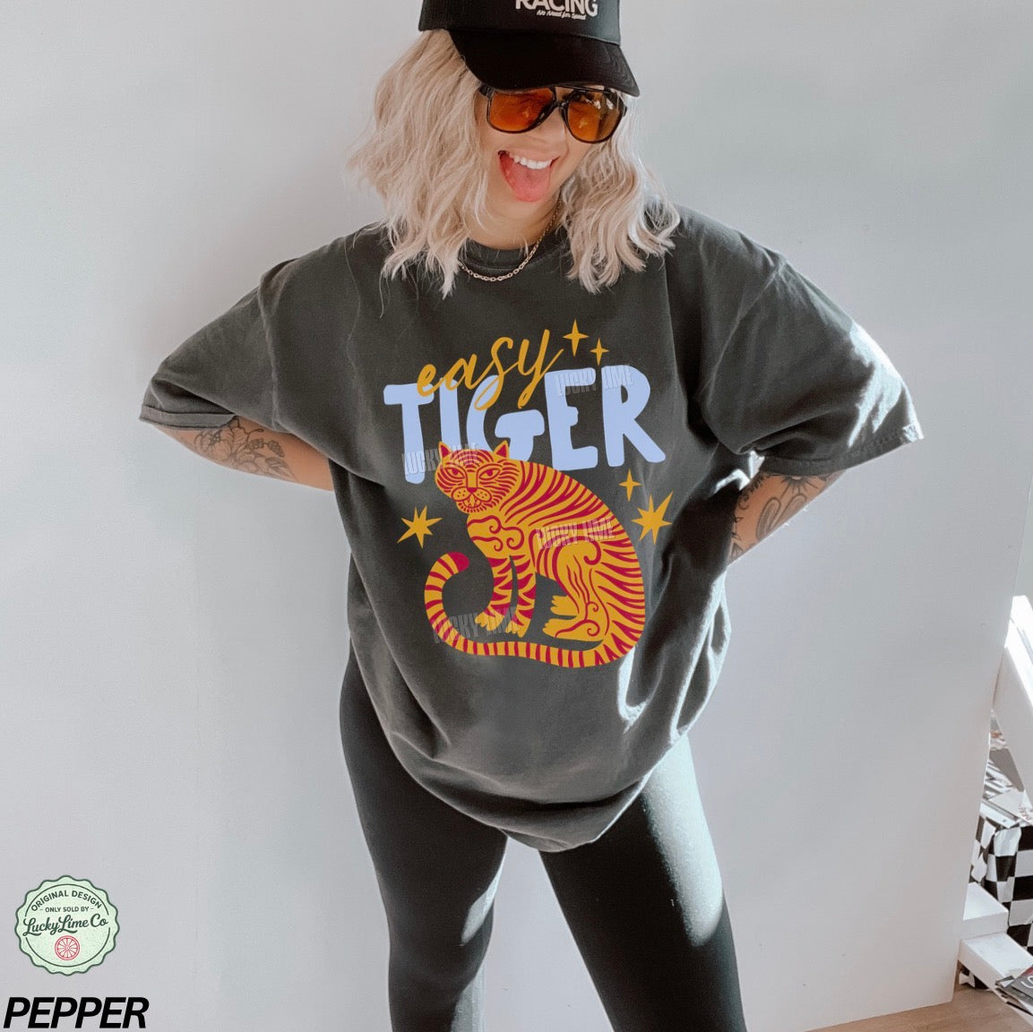 Person wearing a gray oversized t-shirt with a tiger graphic and 'easy tiger' text, standing against a plain background.