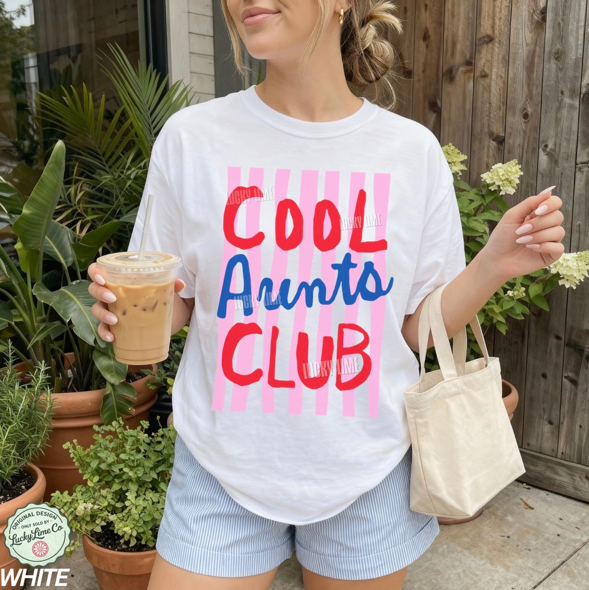 Woman wearing and white colored shirt with pink striped design that says “cool aunts club”