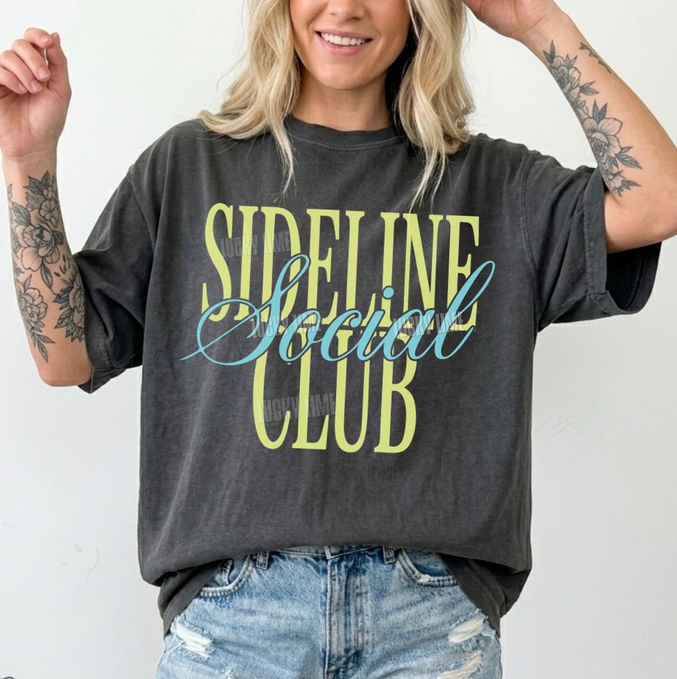 Person wearing a 'Sideline Social Club' t-shirt with denim shorts on a white background