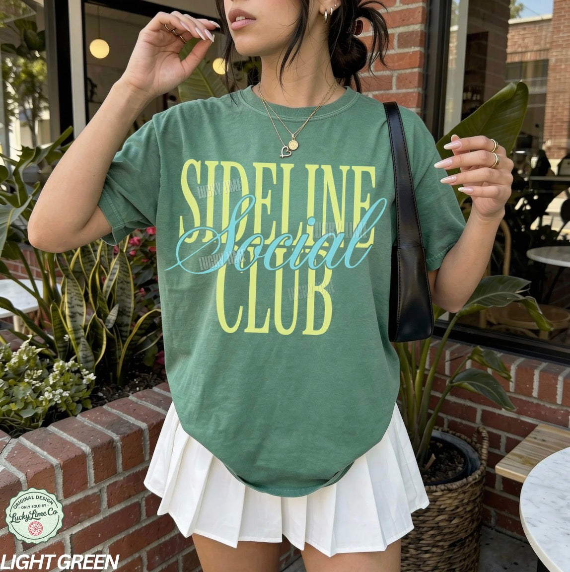 Person wearing a green 'Sideline Social Club' t-shirt outdoors.