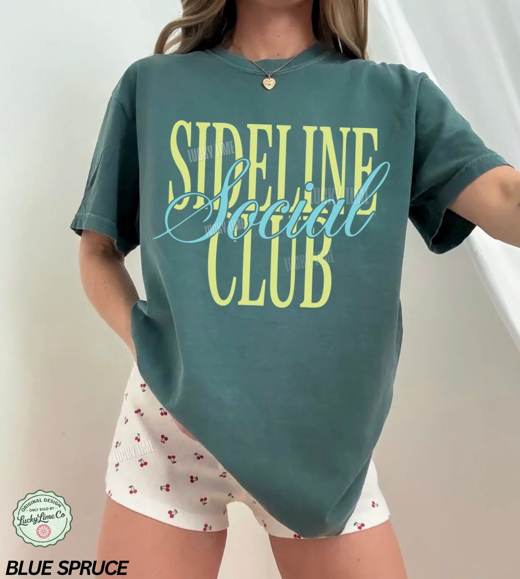 Person wearing a green 'Sideline Social Club' t-shirt and white shorts with red patterns.
