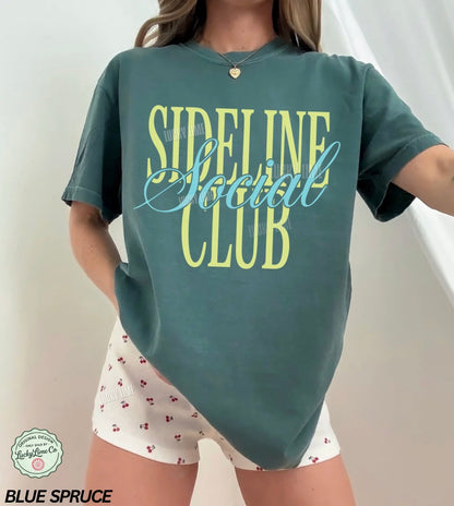Person wearing a green 'Sideline Social Club' t-shirt and white shorts with red patterns.