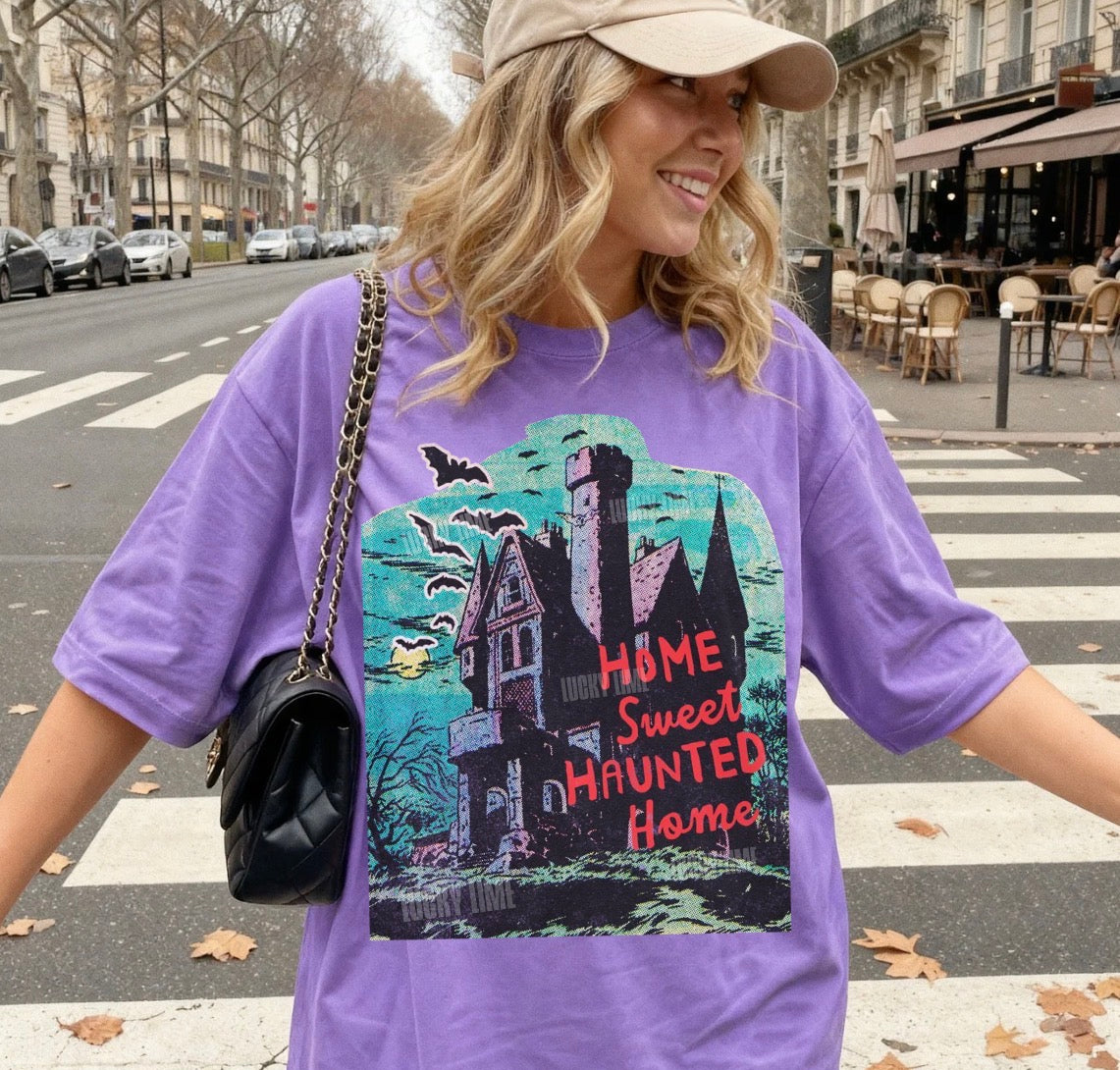 Woman wearing a purple t-shirt with a haunted house design on a city street.