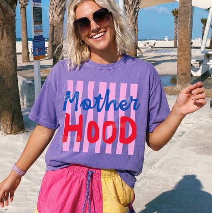 Person wearing a purple 'Mother Hood' t-shirt at a beach.
