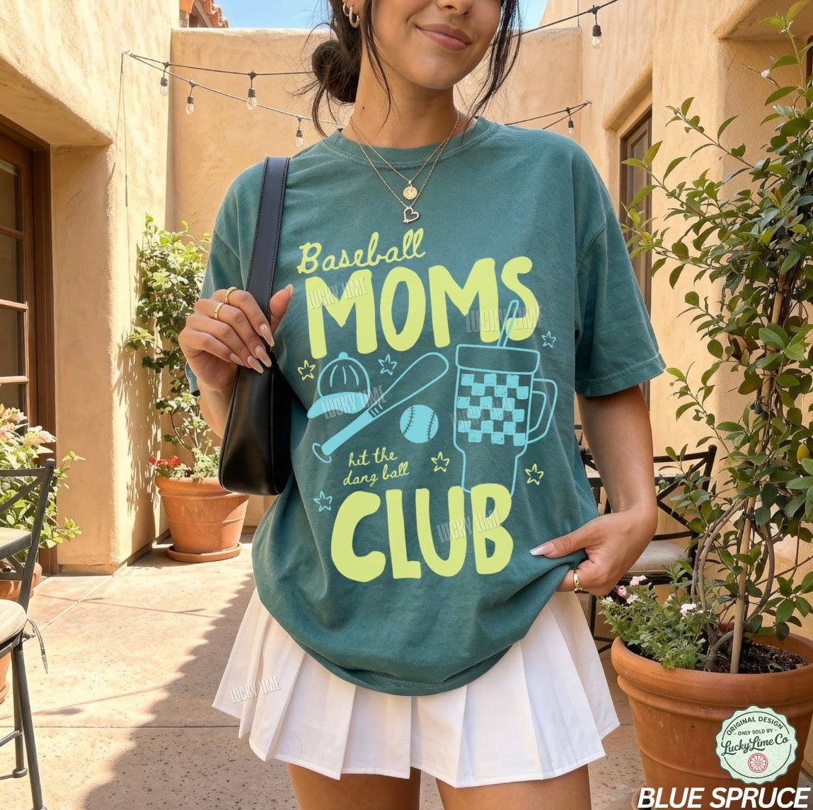 Woman wearing a teal t-shirt with 'Baseball Moms Club' design outdoors.