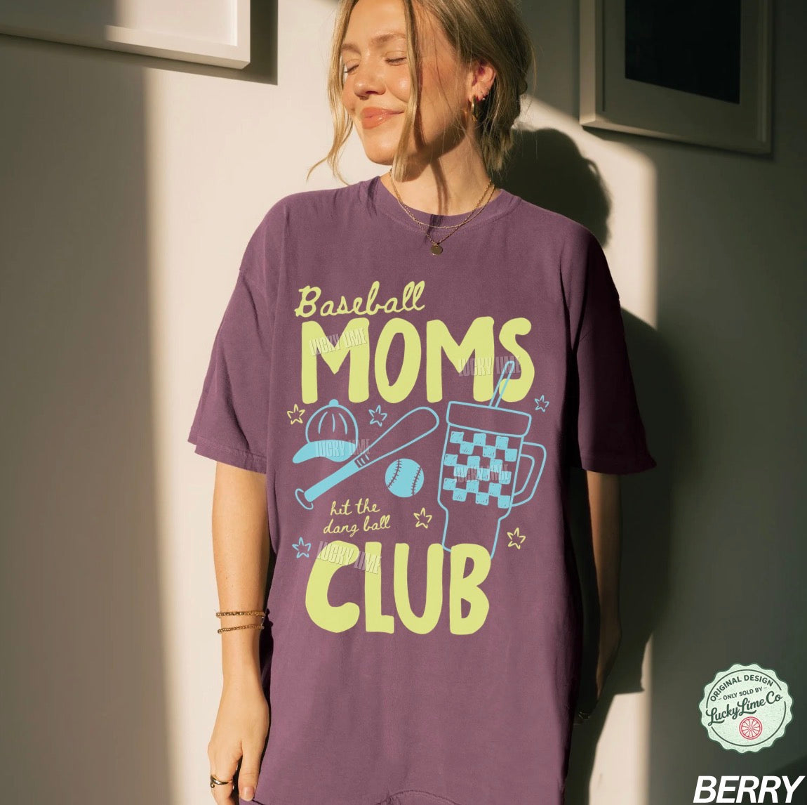 Person wearing a purple t-shirt with 'Baseball Moms Club' text and graphics.