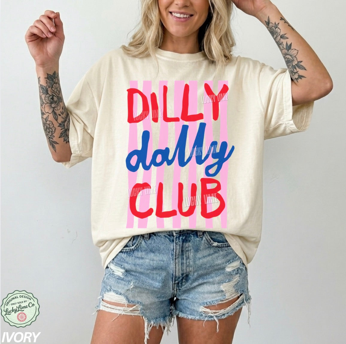 Person wearing a cream t-shirt with 'Dilly dally Club' text and denim shorts on a white background