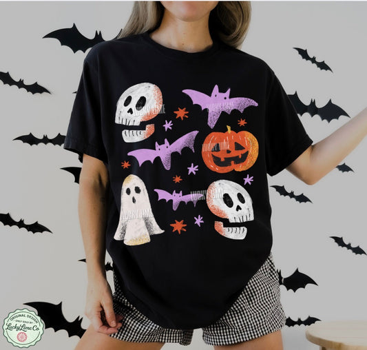 Person wearing a black t-shirt with Halloween-themed graphics on a light gray background with bats.