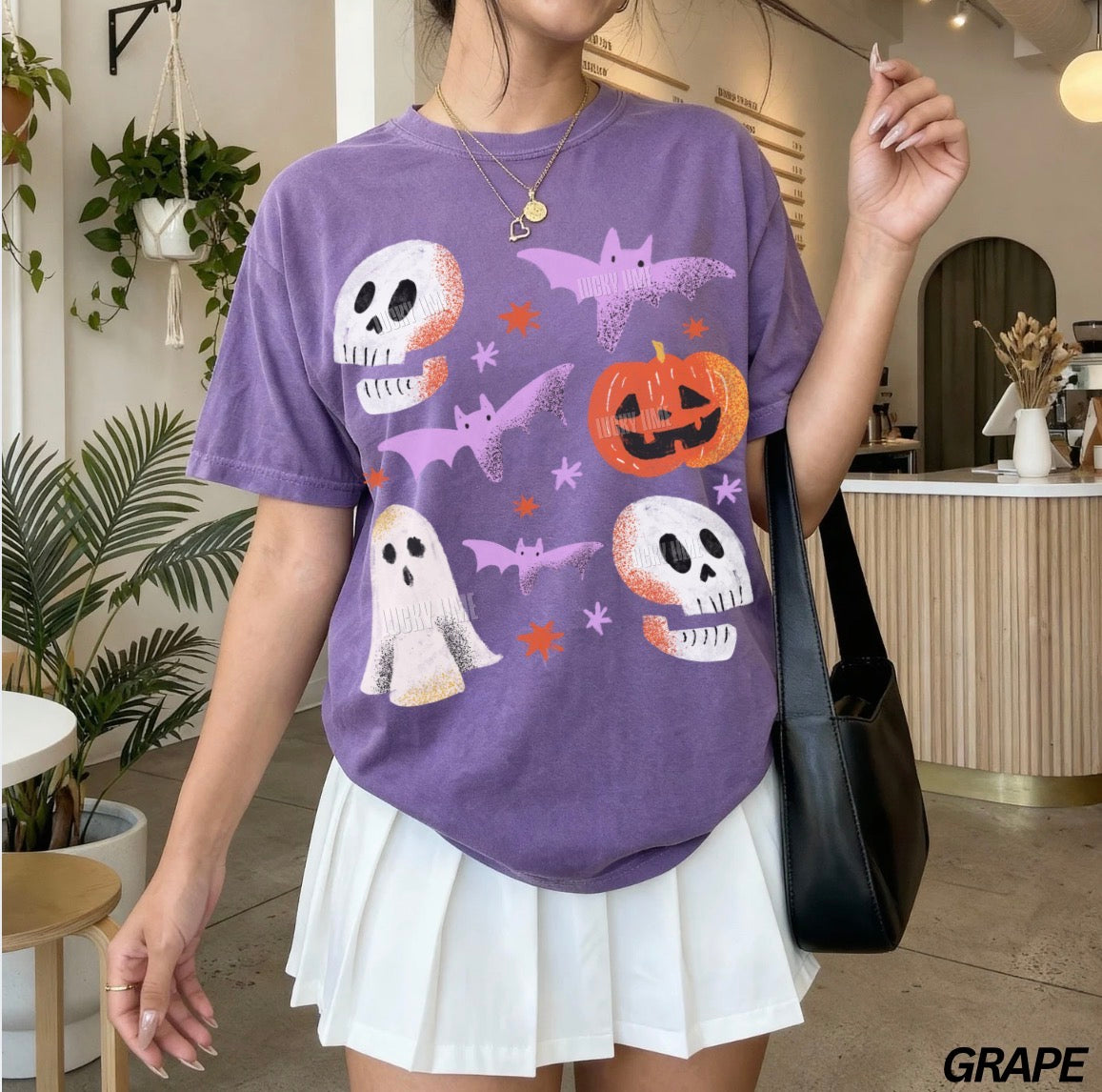 Person wearing a purple Halloween-themed t-shirt in an indoor setting