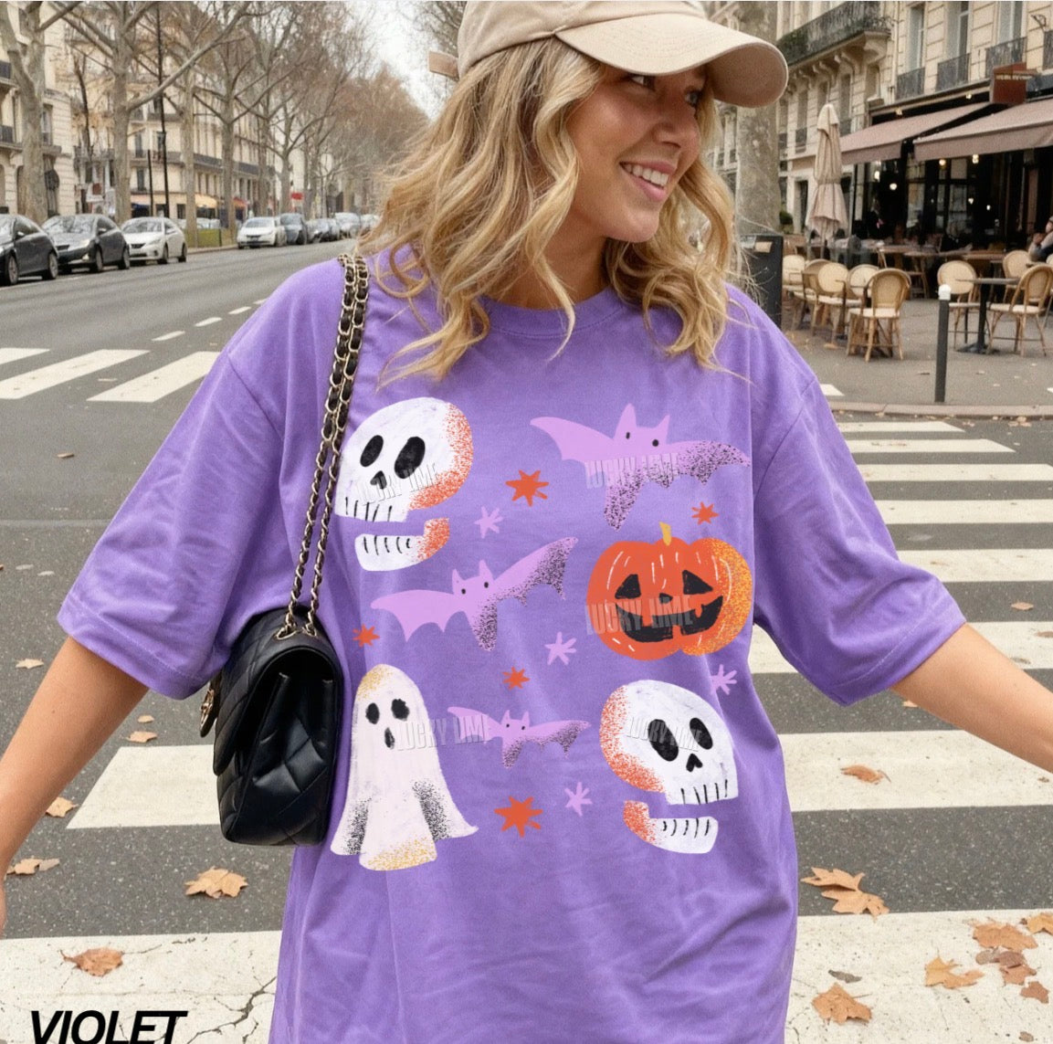 Woman wearing a purple Halloween-themed t-shirt on a city street.