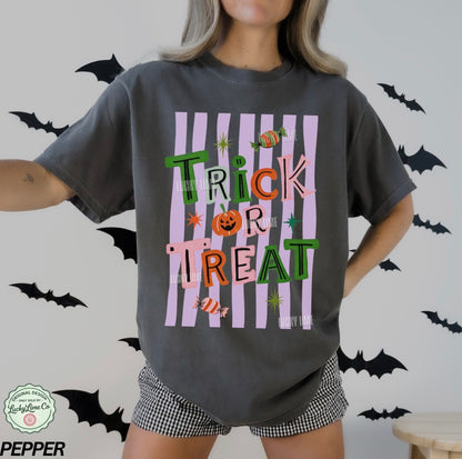 Person wearing a Halloween-themed t-shirt with 'Trick or Treat' design on a gray background with bats.