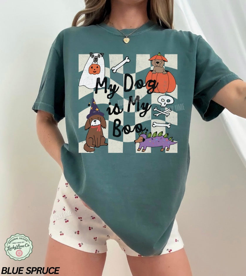 Person wearing a blue spruce t-shirt with Halloween-themed graphics and text, standing against a white background.