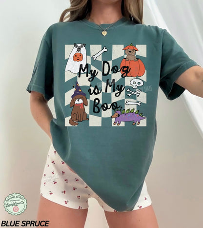 Person wearing a blue spruce t-shirt with Halloween-themed graphics and text, standing against a white background.