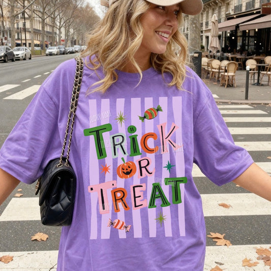 Woman wearing a purple 'Trick or Treat' t-shirt on a city street.